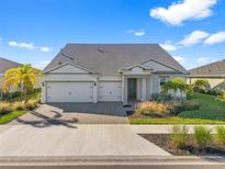 Two-story house with gray roof, white walls, and a three-car garage at 16224 Laurel Oak Ln, Punta Gorda, FL 33982