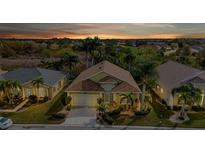 Aerial view of a charming house with a two-car garage and lush landscaping at 1636 Palace Ct, Port Charlotte, FL 33980
