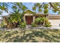 Single-story home with stone accents and lush landscaping at 17032 Ohara Dr, Port Charlotte, FL 33948