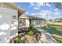 Inviting single-story home featuring a well-manicured lawn and a welcoming front porch area at 7359 Van Lake Dr, Englewood, FL 34224
