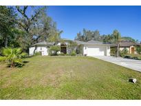 Single-story home with attached garage, and well-manicured lawn at 17080 Kellog Ave, Port Charlotte, FL 33954