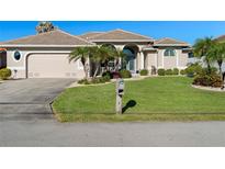 Attractive single-story home with a well-manicured lawn and attached garage at 566 Port Bendres Dr, Punta Gorda, FL 33950