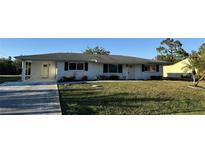 Charming single story home with a well-maintained lawn and carport at 2179 Lakeshore Cir, Port Charlotte, FL 33952