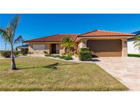 Single-story home with a tile roof, attached garage, and landscaped yard at 2935 Magdalina Dr, Punta Gorda, FL 33950