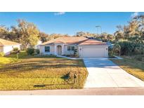 Single-story home with attached garage and well-maintained lawn at 3208 Congress St, North Port, FL 34288