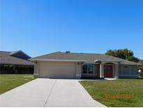 One-story home with attached garage, landscaped lawn, and a neutral color palette at 53 Callao St, Punta Gorda, FL 33983