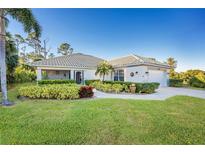 Single-story home with tile roof, landscaped yard, and driveway at 17513 Pomegrante Way, Punta Gorda, FL 33955