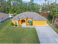 Aerial view of a single-story house with a large yard and driveway at 1762 Foxglove Ave, North Port, FL 34288