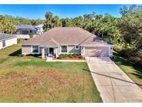 Single-story home with a large yard, driveway, and attached garage at 1858 Capitol St, North Port, FL 34288