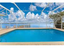 Inviting pool with beautiful water view from a screened enclosure, perfect for relaxation and enjoying the scenery at 3220 Peace River Dr, Punta Gorda, FL 33983