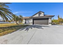 Single-story home with dark garage door at 2387 Tamarind St, Port Charlotte, FL 33948