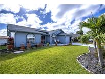 Charming single-story home with well-manicured lawn, attractive landscaping, and inviting curb appeal at 19983 Midway Blvd, Port Charlotte, FL 33948