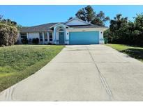 Cute one-story home with a light blue garage door and well-maintained lawn at 6222 Berkeley St, Englewood, FL 34224