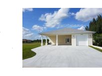 Exterior view of a single-story home with a covered driveway and attached garage at 12090 Malaga Ave, North Port, FL 34287