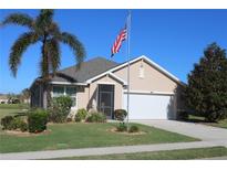 Tan one-story house with a white garage door and palm trees at 7833 Mikasa Dr, Punta Gorda, FL 33950