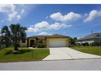 Charming one-story home with yellow siding, a two-car garage, and a well-manicured front lawn at 25115 Esmeralda Ct, Punta Gorda, FL 33955