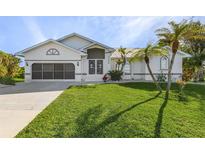 Inviting front yard with palm trees and a well-maintained lawn at 17466 Fuego Ln, Punta Gorda, FL 33955