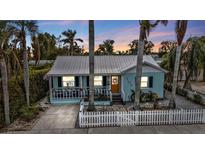 Charming light blue house with white picket fence and a well-manicured lawn at 509 W Olympia Ave, Punta Gorda, FL 33950