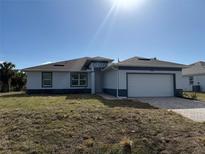 New construction home with a two-car garage and a covered entryway at 12051 Crossgate Ave, Port Charlotte, FL 33981