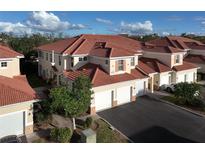 Two-story townhome with tile roof, two-car garage, and landscaped grounds at 240 W End Dr # 311, Punta Gorda, FL 33950