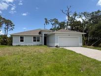 Charming single-story home with a manicured lawn and attached two-car garage at 290 Overbrook St, Port Charlotte, FL 33954