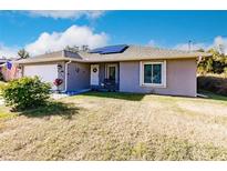 Gray house with a garage and solar panels, nicely landscaped lawn at 5325 Cillette Ave, North Port, FL 34288