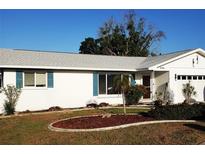 Charming single-story home with manicured lawn and freshly painted white exterior, complete with pleasant landscaping at 806 Hickory Ln, Bradenton, FL 34208