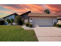 Tan house with brown roof, attached garage, and manicured lawn at 1219 Richter St, Port Charlotte, FL 33952