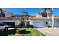 Attractive two-story townhome with tile roof, attached garages, and lush landscaping at 197 Tropicana Dr # 1512, Punta Gorda, FL 33950