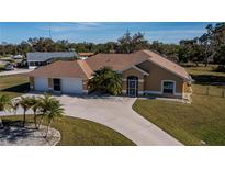 Tan house with palm trees and a large driveway at 3262 Steadman St, Punta Gorda, FL 33980