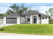 Modern home with a black garage door, impact windows, and a well-manicured lawn showcasing curb appeal at 4301 Marcella Ter, North Port, FL 34286
