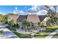 Charming yellow two-story home with a covered front porch and landscaped yard at 1064 Harbour Way Pl, Punta Gorda, FL 33983
