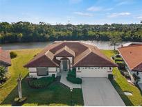 Attractive waterfront home with tile roof, attached garage, and landscaped yard at 1946 Cove Pointe Dr, Venice, FL 34293