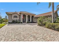 Beautiful one-story home with a brick paver driveway and lush landscaping at 3230 Bay Ridge Way, Port Charlotte, FL 33953