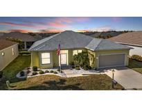 Beautiful yellow house with gray roof, landscaping, and a two-car garage at 1766 Dunvegan Dr, Punta Gorda, FL 33980