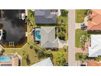 Aerial view highlighting the house with a pool, surrounded by lush landscaping and waterfront access at 210 Divinci Dr, Punta Gorda, FL 33950
