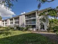 Beautiful condominium complex featuring multiple screened lanais and well-maintained landscaping under a sunny sky at 437 Cerromar Ln # 312, Venice, FL 34293