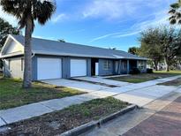 Ranch-style home with a two-car garage and mature landscaping at 627 Palm Ave, Punta Gorda, FL 33950