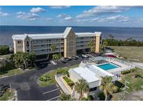Aerial view of waterfront condo building with pool and parking at 101 N Marion Ct # 225, Punta Gorda, FL 33950