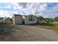 Single-wide manufactured home with shed and gravel driveway at 12415 Catalina Dr, Punta Gorda, FL 33955