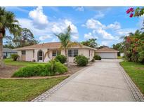 Single-story house with a paved driveway and landscaped yard at 1713 Belvidere Rd, Englewood, FL 34223