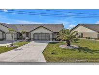Front view of charming villa with two-car garage and landscaped yard at 26155 Explorer Rd # 1C, Punta Gorda, FL 33983