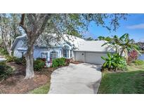 Charming home featuring a well-manicured lawn, lush landscaping, and a convenient two-car garage at 3116 Silkwood Ln, Port Charlotte, FL 33953