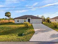 Newly built home with a two-car garage and well-manicured lawn at 8429 Malcolm Ave, North Port, FL 34287