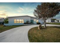 Charming mid-century home with a circular driveway and manicured lawn at 115 Leland Se St, Port Charlotte, FL 33952