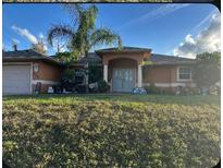 One-story home with attached garage, palm trees, and a manicured lawn at 3323 Sikeston Ave, North Port, FL 34286