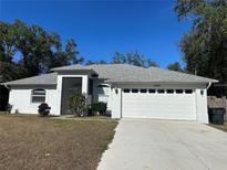 White single-story house with a two-car garage and landscaping at 6146 San Salvador Rd, North Port, FL 34291