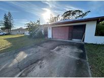 Ranch style home with carport and mature landscaping at 1125 Hinton St, Port Charlotte, FL 33952