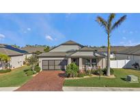 One-story home with brick paver driveway, screened-in garage, and landscaped yard at 15292 Mille Fiore Blvd, Port Charlotte, FL 33953