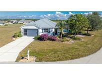 Single-story home with gray metal roof, attached garage, and landscaped yard with pool at 24490 Wallaby Ln, Punta Gorda, FL 33955